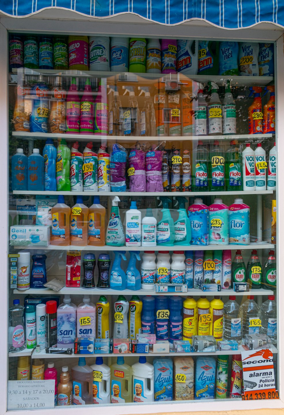 Prodotti per la pulizia e articoli per la casa disposti in una vetrina.