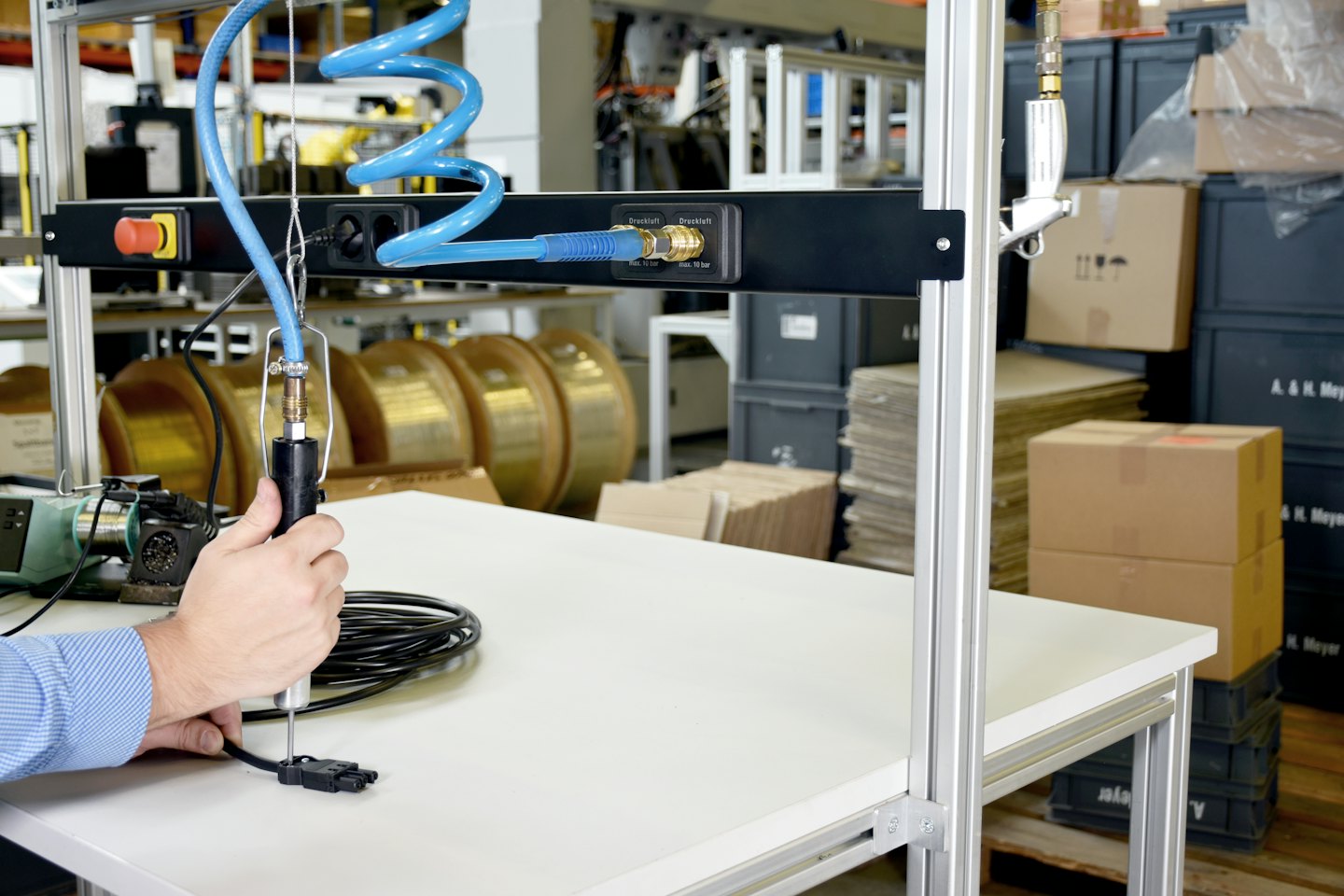 Mani usano un utensile pneumatico per assemblare un componente elettronico.